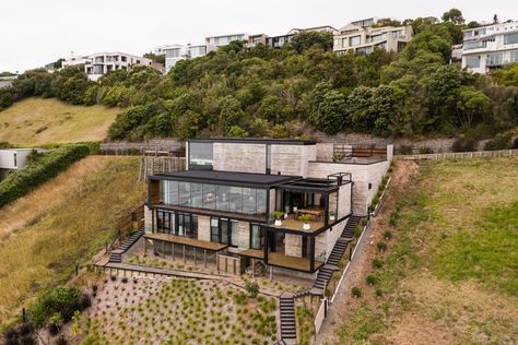 Concrete was a necessity on the very steep, geotechnically challenging site, so we chose to embrace it. Steep Hillside House, Downhill House, Slope House Design, House On Slope, Cedar Shiplap, Sloping Lot House Plan, Slope House, Polished Concrete Flooring, Hillside House