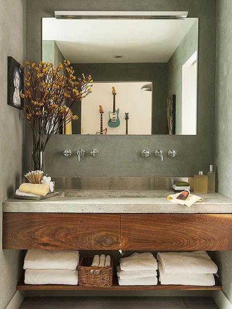 A concrete countertop and stainless-steel backsplash provide a contemporary feel to this small space. Concrete Bathroom Design, Bilik Air, Glamorous Bathroom, Stainless Steel Backsplash, Concrete Bathroom, Bad Inspiration, Bathroom Design Inspiration, Trendy Bathroom, Modern Bathroom Vanity