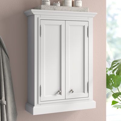 This wall-mounted, 2-door bathroom cabinet saves you space while creating functional storage. It's crafted from solid birch wood in a neutral hue that goes with a variety of color schemes. The design features a rectangular shape with crown molding at the top and picture frame paneling on the cabinet doors. We love that they open to reveal compartments separated with an adjustable shelf - so you can store anything from shampoo to cotton swabs. It's wall-mounted, so it's ideal for just over the to Cabinet Above Toilet, Large Bathroom Cabinets, Wall Bathroom Cabinet, Wall Mounted Bathroom Cabinet, Kitchen Appliance Set, Wood Wall Bathroom, Bathroom Cabinets Designs, Wall Mounted Bathroom Cabinets, White Bathroom Cabinets