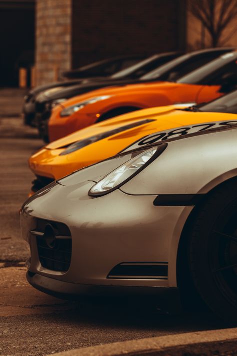 Line up at a car meet in downtown Indianapolis. A grey Porche, then a yellow and orange car, with two black cars in the background. Sport Car Photography, Car Style Photography, Two Cars Photography, Cool Pictures Of Cars, Super Car Photography, Cars Lined Up, Professional Car Photography, Race Car Photography, Jdm Car Photography