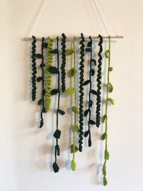 Wall hanging decor product with white background. The product is a Dowel rod with lots of Green crochet vines hanging off the rod. Light and dark green shades - spiral vines, small leaf and large leaf vines - 10 hanging pieces in total in various lengths Amigurumi Patterns, Blankets Hanging On Wall, Crochet Leaves Wall Hanging, Crochet Charger Cord Vine, Crochet Vines And Leaves Pattern, Crochet Vines, Vine Crochet, Crochet Vine, Cottagecore Tapestry