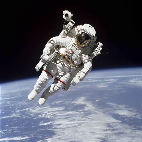 Image: This Feb. 7, 1984 photo made available by NASA shows astronaut Bruce McCandless II, participating in a spacewalk a few meters away from the cabin of the Earth-orbiting space shuttle Challenger, using a nitrogen-propelled Manned Maneuvering Unit. Background Stars, Space Shuttle Challenger, Sky Stars, Nasa Astronauts, Astronauts In Space, Space Photos, Apollo 11, Space Pictures, Space Suit