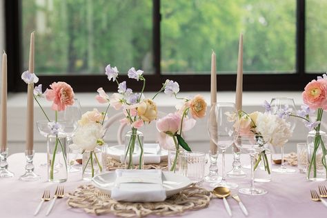 Delicate spring flowers in bud vases with taper candles Spring Wedding Inspiration at Urban Daisy | Denae Brennan Events Pastel Bud Vase Centerpiece, Flower Bud Vases Table, Peach Bud Vases Wedding, Bud Vases Flowers Wedding, Glass Taper Candle Holders Wedding, Head Table Bud Vases And Candles, Wedding Flowers Arrangements Table, Bud Flower Arrangement Wedding, Bud Vases And Candles Centerpiece Long Table