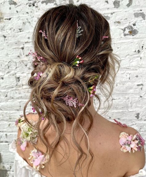 Wavy Bun with Flowers Flower Hairstyles Updo, Hair Styles Prom Updo, Fairy Princess Wedding Hair, Floral Updo Hairstyles, Enchanted Garden Hairstyle, Garden Fairy Hair, Summer Bride Hairstyles, Fairytale Updo, Messy Bun With Flowers