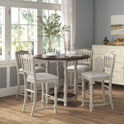 Round out a cozy breakfast nook or your eat-in kitchen with this elegant 5-piece dining set. It includes a counter-height table and four stools, all crafted from solid and engineered wood with a weathered brown and gray finish, and they rest on turned legs. The round table features a built-in shelf on the bottom to accommodate basket and extra cutlery. And the slat-back counter stools are padded with a polyester blend for cushioned support while you sit for a weeknight meal or Sunday brunch. Plu Round Counter Height Dining Table, Round Counter Height Table, Cozy Breakfast, Cozy Breakfast Nook, Dinning Set, Pub Table Sets, Counter Height Dining Table, Height Table, Counter Height Table