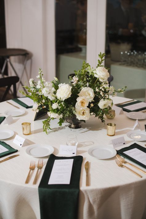 Low floral centerpieces for elegant winter wedding overflowing with white garden roses, dried hydrangeas, scabiosa, berries, lisianthus, ranunculus, and natural dark greenery. Designed by Rosemary and Finch in Nashville, TN. White And Green Winter Wedding Centerpieces, White Candle And Greenery Centerpiece, White Rose And Pine Centerpiece, Green And White Flower Arrangements Wedding, White Wedding Arrangements Centerpieces, Green And White Wedding Round Table Decor, All White Wedding Tablescape, White Floral Centerpieces Wedding Low, White Flower Table Centerpiece