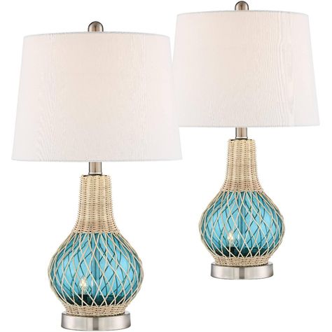 Trust the skilled artisans at 360 Lighting to produce an unforgettable decor accent with sleek, simple taste and a lush palette. Fashioned from blue finish glass, this set of two table lamps features glass bodies over metal bases, with each lamp embellished with wicker accents and partially wrapped in charming rope trim. Coastal meets Mid-Century Modern retro style to fashion a set of lamps with versatility and personality. Four-way switches include a night light setting, making these lamps a pe Neutral Coastal Bedroom, Coastal Accent Table, Boho Coastal Bedroom, Rental Bedroom, Nautical Decor Living Room, Coastal Chic Living Room, Modern Coastal Bedroom, Blue Glass Lamp, Boho Coastal Decor