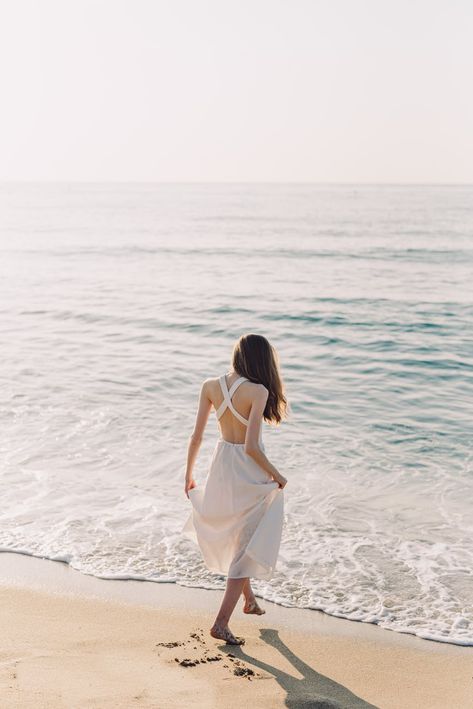 A Woman in White Dress Walking on the Beach · Free Stock Photo Photoshoot Ideas At Beach, Walking In The Beach, Ocean Poses, Woman Walking On Beach, Woman Walking On The Beach, Maldives Honeymoon Package, Woman At The Beach, Best Beach Destinations, Woman In White Dress