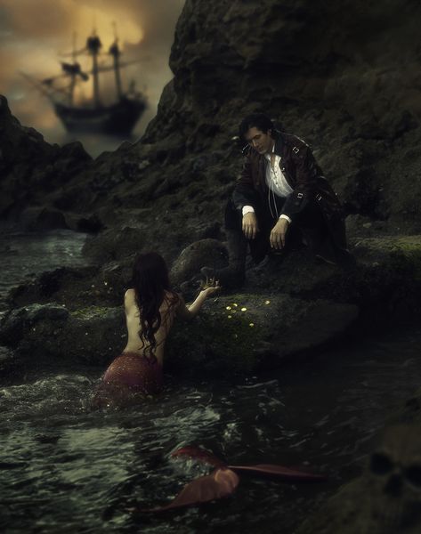 A pirate leans over the water as a mermaid brings him a crown and coins inside a sea cave.  A pirate ship is seen in the background Pirate Photoshoot, Mermaid Romance, Pirate And Mermaid, Mermaid Shoot, Mermaid Photo Shoot, Mermaid Photoshoot, Aesthetic Mermaid, Pirate Photo, Fairytale Photoshoot