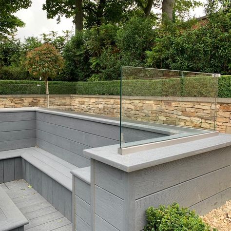 This fabulous garden fire pit seating area was finished off to perfection by the addition of a frameless glass balustrade.
Toughened glass balustrades are ideal for garden features like fire pits. Safe, weather-proof, durable and utterly stylish, they'll keep your outdoor space looking good for years.
For more design inspiration like this, see our gallery at www.glassmirrorsolutions.co.uk/gallery or call our Durham glass sales team on 0191 3758700. Balustrades Outdoor, Glass Balustrade Outdoor, Garden Fire Pit Seating, Tiered Patio, Circular Garden Design, Glass Fencing, Balustrade Design, Garden Sitting Areas, Sunken Patio