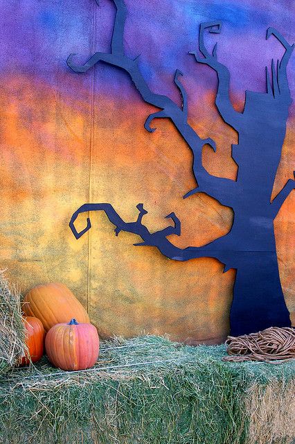 Fall Photo Backdrop: spooky back drop with blackish purple spooky tree and orange and yellow darkened sky; bail of straw and pumpkins at the forefront. Good for fall or Halloween party (don't forget some bats!):) School Halloween Photo Backdrop, Spooky Photo Backdrop, Haunted House Backdrop, Halloween Picture Backdrop Diy, Diy Fall Photo Backdrop, Fall Dance Ideas, Fall Fest Decorations, Fall Picture Backdrop Ideas, Diy Halloween Backdrop For Pictures