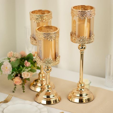 PRICES MAY VARY. Quantity: 3 Set of Candle Holders Material: Metal Stand & Glass Color: Gold Glass Color: Amber Sizes: 13" | 15" | 17" Base Diameter: 5" Glass Container Height: 6" Glass Container Diameter: 4" HIGH QUALITY: These candle holders are made from high-quality premium material. To make things swankier, we have designed it on the master of luster. This elegantly shimmering piece comprises shiny material crafted with the utmost perfection. CAPTURES ATTENTION: These candle holders will ad Votive Candle Stand, Candles Collection, Glass Pillar Candle Holders, Relaxing Candles, Candle Stands, Small Candle Holders, Glass Votive Candle Holders, Gold Candle Holders, Large Candle Holders