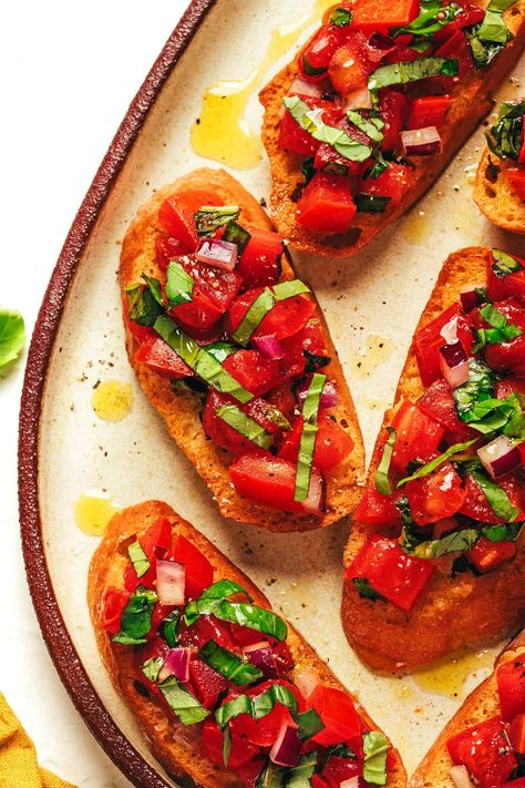 Everything we learned in Italy about how to make the best bruschetta with crusty bread, ripe tomatoes, basil, oregano, onion, garlic and olive oil. It's a simple appetizer that's easy to prep in advance and always a crowd fave. Feel free to add cheese, balsamic, salami or other fun extras if you'd like! | gimmesomeoven.com Tomato Basil Bruschetta, Best Bruschetta, How To Make Bruschetta, Dips Appetizers, Simple Appetizer, Garlic And Olive Oil, Tomato Bruschetta, Tomato Season, Bruschetta Recipe