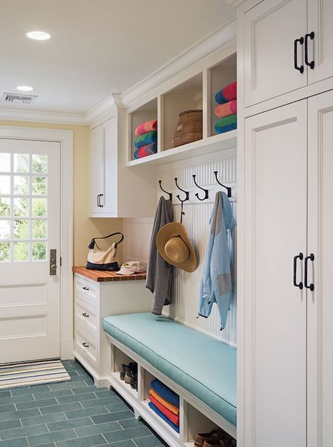 Cottage mudroom features full height shaker cabinets adorned with oil-rubbed bronze hardware beside a built-in bench topped with turquoise cushion under a beadboard backsplash lined with row of hooks under cubbies filled with beach towels next to catchall countertop atop turquoise floor tiles laid out in brick formation. Cottage Laundry Room, Vstupná Hala, Small Mudroom Ideas, Hal Decor, Farmhouse Mudroom, Mud Room Entry, Mudroom Organization, Mudroom Entryway, Mudroom Decor