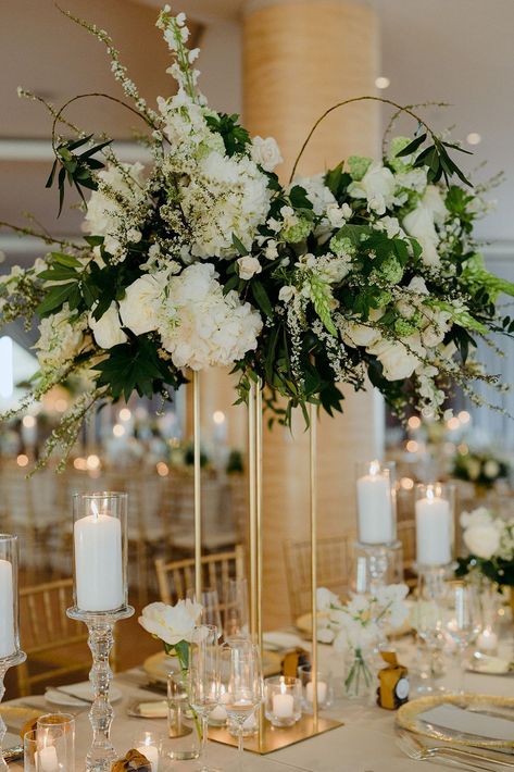 For a glamorous wedding centerpiece, opt for tall floral arrangements in gold stands. We love this for an indoor summer wedding. Click for more beautiful glamorous wedding ideas. // Photo: Alixann Loosle Gold White And Green Floral Arrangements, Tall White And Green Centerpiece Wedding, White And Green Flower Arrangements Wedding, Gala Floral Centerpieces, Sage Green And Gold Centerpieces, White And Green Table Decor, Tall Gold Centerpieces, Ballroom Centerpieces, Green White And Gold Wedding