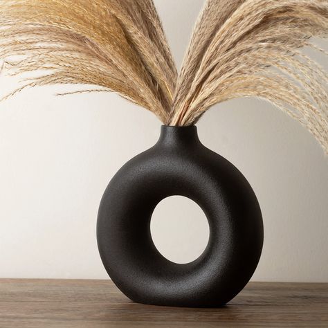 PRICES MAY VARY. PAMPAS VASE FOR BLACK ROOM DECOR - The black modern vase is ideal for minimalist decor; its circle vase with hole, round black shape offers aesthetic vase accent,for blackfarmhouse decor, black bedroom decor. Material: 100% ceramic vase, this textured vase has matte finish on the surface, slightly rough to the touch which feels vintage and rustic, size: 19cm*18cm*6cm/7.5inches*7inches*2.4inches. Shape: Donut/doughnut. Color: black. Weight: 1.9lbs/860grams. BLACK CERAMIC VASES FO Black Accessories Living Room, Black Vase Decorating Ideas, Black And Tan Decor, Bedroom Vase, Black House Decor, Pampas Vase, Aesthetic Vase, Modern Shelf Decor, Office Decor Black