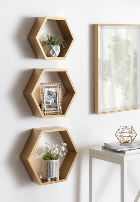 The Putnam Hexagon Shelf Set is the ideal way to add geometric intrigue to your overall decor aesthetic. Inspired by mid-century modern decor, the Putnam Shelf Set has an on-trend hexagon shape with a gold finish. This set is unique in its graduated sizing, with the largest standing at 14.5 inches high by 16.5 inches wide, the medium at 12.5 inches high by 14.5 inches wide, and the smallest coming in at 10.5 inches tall by 12 inches wide. These graduated sizes also allow you to nest them in one Diy Wood Hexagon, Hexagon Shelf Decor, Wall Mounted Shelving, Hexagon Shelf, Wood Floating Shelf, Wood Hexagon, Honeycomb Shelves, Honeycomb Shape, Hexagon Shelves