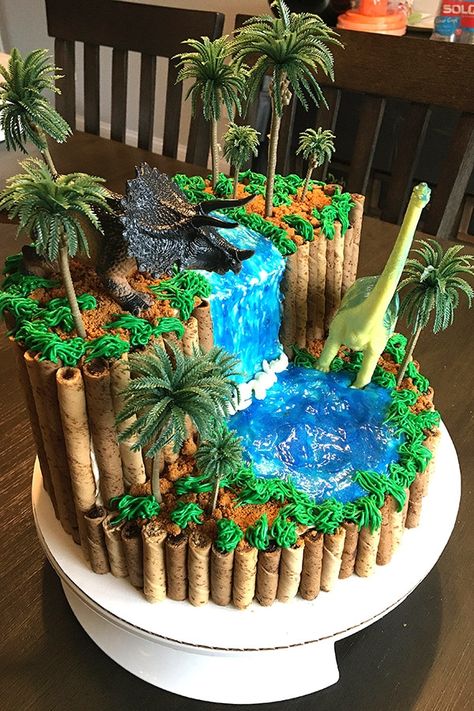 Throwing a dinosaur themed birthday party for your boy - or girl? This easy dinosaur birthday cake will blow the pants off everyone. From a 3rd birthday to a 20th, this awesome-looking cake can be appreciated by any dino fan. A homemade dinosaur cake has never been easier, even with the DIY waterfall! This dinosaur cake uses NO fondant, it's strictly buttercream, sparkle gel, and a couple of cookies. (No one will even mind that the dinosaurs and trees are plastic, because it looks cool anyway.) Dinosaur Cakes For Boys, Dino Birthday Cake, Dinosaur Birthday Theme, Jurassic Park Birthday, Dino Cake, Dinosaur Birthday Cakes, 4th Birthday Cakes, Dinosaur Themed Birthday Party, Dino Birthday Party