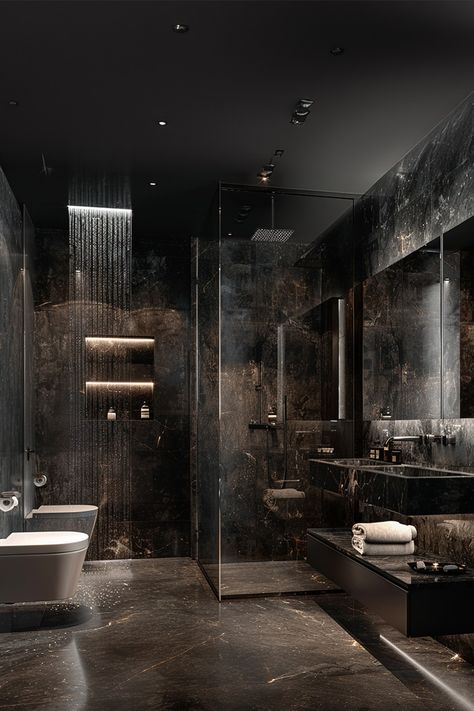 Luxurious Black Marble Bathroom • This stunning bathroom features sleek black marble walls and floors for an ultra-luxe look. • A rainfall showerhead offers a spa-like experience, perfectly complemented by built-in shelves with soft lighting. • The minimalist white bathtub contrasts beautifully with the dark tones, adding a touch of elegance. • Glass partitions and floating vanity keep the space modern and airy. • Subtle LED lighting highlights the rich marble textures Luxurious Black Bathroom, Black Master Bathrooms Luxury, Dark Luxury Bathroom Master Baths, Black Gold Marble Bathroom, Dark Ocean Bathroom, Downstairs Shower Room Ideas, Toilet And Bathroom Design Modern, Dramatic Bathroom Ideas, Black Marble Shower Walls