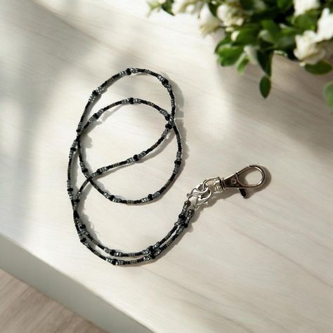 This Gray and Black beaded eyeglass chain is the perfect addition to your accessories! Not only is it an eyeglass chain, it is interchangeable and functions as a beautiful lanyard or even an earbud chain.  Express your style and personality with this Seed Bead Gray and Black eyeglass chain that embodies both charm and utility in one stunning piece. Effortlessly transition from professional to casual settings with this versatile and chic lanyard that is bound to become a staple accessory in your wardrobe. Included in your purchase are a pair of eyeglass chain ends and a lanyard clasp. To switch, simply use the small clasps at each end of the beaded chain.  This black and gray eyeglass chain is 32 inches long. Nurse Lanyard, Eyeglasses Chain, Chain Sunglasses, Ear Bud, Eyewear Chain, Black Lanyard, Sunglasses Holder, Beaded Lanyard, Beaded Lanyards