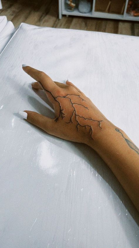 250+ Lightning Tattoos Ideas and Designs (2023) - TattoosBoyGirl Hand Tattoos Lightning Bolt, Hand Tattoos For Guys Lightning, Lightning Tattoo Men Hand, Hand Tattoos For Women Lightning, Lightning On Hand Tattoo, Electricity Hand Tattoo, Hand Lighting Tattoo, White Ink Lightning Tattoo Hand, Lightening Bolt Hand Tattoo