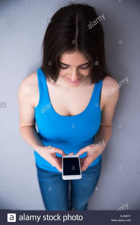 Download this stock image: Top view portrait of a happy woman using smartphone over gray background. Wearing in blue t-shirt and jeans. - EJW81T from Alamy's library of millions of high resolution stock photos, illustrations and vectors. Top Down View Perspective, Pose Reference Top View, Head Top View, Top View Reference, Top Down Perspective, Perspective Practice, Three Point Perspective, Body Paintings, Drawing Anatomy