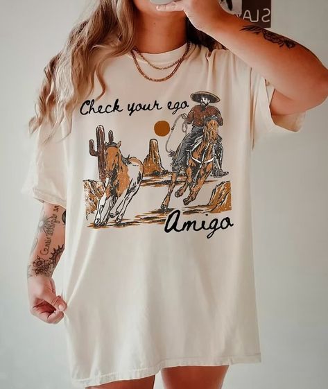 Me after @thetinderblog shares one of my memes… Check Your Ego Amigo! Retro Tee Design, Vintage Western T Shirts, Vintage Western Graphic Tees, Cowgirl Graphic Tees, Cowboy Graphic Tees, Western Shirt Ideas, Vintage Cowgirl Outfits, Western T Shirts, Texas T Shirt