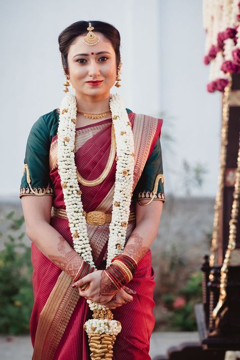 Photo of South Indian bride dressed in a maroon saree with a dark green blouse. Maroon Saree Blouse Combination, Maroon Bridal Saree South Indian, Indian Bride Dresses, Dark Green Blouse, Silk Saree Blouse Designs Patterns, Red Sari, Green Color Combinations, Maroon Saree, Combination Dresses