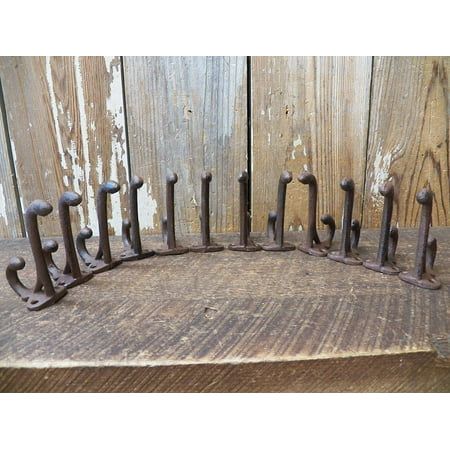 Set of 12, small cast iron hooks. The top hook will extend about 3 1/4", the bottom 1 3/8" from the wall. The holes are 7/8" apart at center and are 3/16" across. The weight they will hold will depend on your specific installation of them. These do not include screws. Important *This item was manufactured to look antique, expect some built in imperfections. Color: Brown. Key Hangers, Cast Iron Hooks, Vintage Styling, Hat Hooks, Key Hanger, Coat Rack Wall, Wall Mounted Coat Rack, Big Sky, Metal Hooks