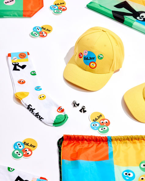 Our client @frasers_property_australia comissioned the cutest merch ever for one of their shopping centres. 🩵💛🧡💚 Ed.Jnr is a brand new kids club at Ed.Square Shopping Centre. The quality product suite features our Wonderpack, Watson Cap, Cheerful socks, Vinyl stickers and Cutie Pins - fully customised with Ed Jnr bright, fun branding. The purpose of this merch is to give out to new kids when they sign up to join the club. Score! Gen Z Merch, Fun Merch Ideas, Club Branding Design, Gen Z Stickers, Bakery Merch, Merch Ideas Products, Merch Branding, Merch Photography, Event Merch