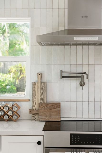 Step into the dreamiest of modern coastal kitchens at Lindross Remodeling! 💖🌊✨ With our elegant dimensional vertical stacked subway tiles and white cabinets you won't want to leave. Pin this kitchen for later and start planning your own coastal haven! 🏡✨📍 Pin for later!📌 #lindrossremodeling #lindrosshome #subwaytile #whitesubwaytile #moderncoastal #californiacoastal #tampadesign #tampadesignbuild #tamparemodel #potfiller #cuttingboard #woodaccents Vertical Stack Subway Tile Kitchen, Chloe Tile Vertical, Bedrosians Tile Kitchen, White Rectangle Tiles Kitchen, Horizontal Tiles Kitchen, Kitchen Vertical Subway Tile, White Subway Tile With Accent Strip, White Vertical Subway Tile Kitchen, Vertically Stacked Subway Tile Kitchen