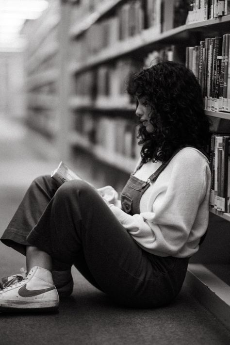A black and white photograph of a woman sitting on the ground of a library reading a book. Photoshoot In A Library, Nerdy Photoshoot Ideas, Book Theme Photoshoot, Bookstore Photoshoot Photo Ideas, Library Themed Photoshoot, Family Photos In Library, Library Pics Photo Ideas, Author Picture Poses, Library Portrait Photography