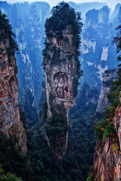 The truth:: The tree spires are real, but that Buddha carved into the side? Totally Photoshopped. Amazing Nature, Sejarah Kuno, High Fantasy, Bhutan, Rock Formations, Magical Places, Beautiful Places To Visit, Places Around The World, Nature Travel