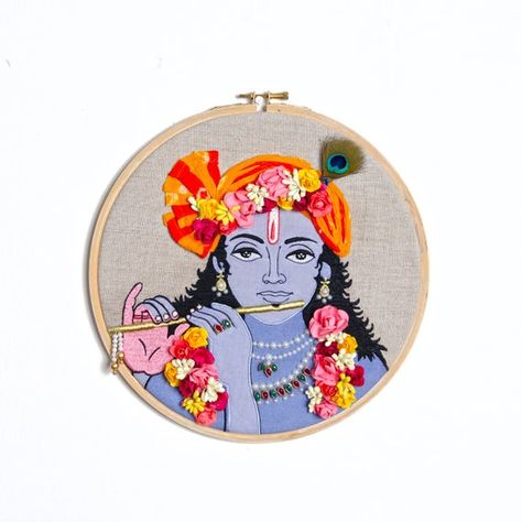 KANHA HOOP WALL ARTSize: 10 inch diameterMaterial: wood and brass hoop, linen fabric baseThe embroidered linen fabric is neatly secured in a 10 inch hoop. Back is finished and lined with matching cotton fabric to hide the threads and knotsThis embroidery hoop wall art can be hung on the wall by the top screw, or a ribbon and is just as nice simply propped up on a shelf.The very eternally charming and lovable Krishna is intricately embroidered and crafted on the hoop for you.The eye catching piec Embroidery Designs Krishna, Embroidery Hoop Painting, Krishna Embroidery Designs, Embroidery Hoop Art Diy Free Pattern, God Embroidery Designs, Indian Embroidery Patterns, Krishna Embroidery, Framed Embroidery Wall Art, Canvas Embroidery Art