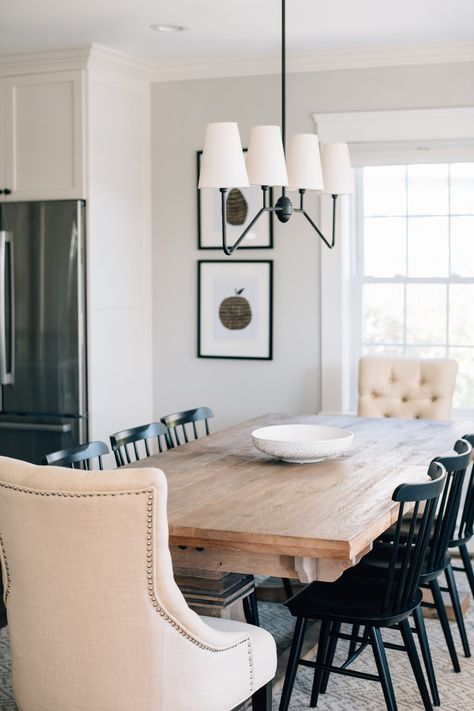 Gray Oak Studio - Prospect Project - Dining Room - Linear Chandelier- Matte Black fabric shade four light rejuvenation chandelier, 8 person table, washed wood modern rustic farmhouse table, modern black Windsor chairs, tufted ivory captain chairs, apple and pear wall art Dining Room Captain Chairs, Black Windsor Dining Chairs Wood Table, Dining Table With Captain Chairs, Dining Room With Windsor Chairs, Farmhouse Dining Room Table For 8, Farmhouse Table Light, Oak Windsor Dining Chairs, Light Dining Room Table With Black Chairs, 8 Person Dining Room Table