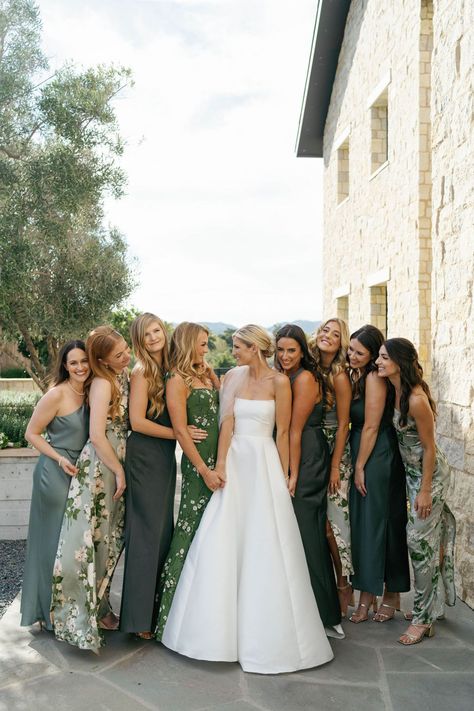 classic bride in an elegant strapless wedding dress with her bridal party in mismatched floral and solid green bridesmaid dresses Same Color Different Dress Bridesmaids, Bridesmaids With Different Dresses Same Color, Bridal Party Different Dresses, Casual Green Bridesmaid Dresses, August Wedding Bridesmaids, Green Bridesmaid Mismatched, Floral Mix And Match Bridesmaid Dresses, Elegant Green Bridesmaid Dresses, Fall Wedding Green Bridesmaid Dresses