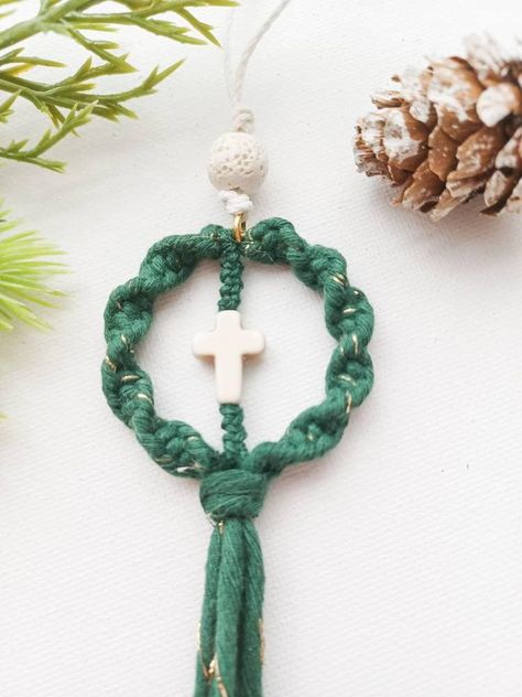 Macrame Cross lava bead diffuser. This faith-based ornament is a unique gift for Bible study groups, family, friends, and coworkers.  Also, it can be used as a rear-view mirror car charm. The lava bead serves as a diffuser. Just add a few drops  of your favorite essential oil to the bead and enjoy.  * Christmas ornament * Valentine's Day gift * Lava bead car diffuser  * Semiprecious cross bead * Made to order Colors: Red with gold strand  Green with gold strand White with gold strand  Also available without the gold strand.  * Free shipping  on orders over $35 This cute Macramé diffuser is created with macramé  cord, wood beads, and a beautiful semiprecious stone cross bead. If used as a car diffuser, just add your favorite essential oil to the wood bead if you wish and enjoy! Works best I Macrame Cross, Christian Accessories, Cord Wood, New Car Gift, Diy Earrings Easy, Stone Cross, Rear View Mirror Decor, Cross Christian, Car Gift