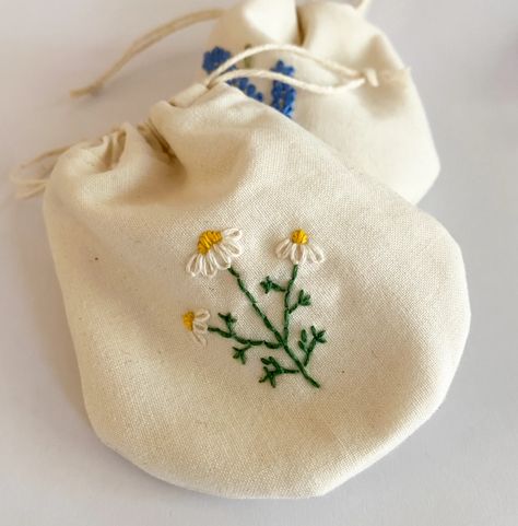 These bags celebrate two of my favorite medicinal herbs — lavender and chamomile. They both bloom in spring, look lovely in bouquets, and have potent medicinal properties.  In the last couple of weeks, I stepped out of my comfort zone-- quilting-- to try out something new-- embroidery. I’ve done embroidery before, and Medicine Embroidery, Chamomile Embroidery, Herb Embroidery, Lavender And Chamomile, Witch Characters, Lazy Daisy Stitch, Spring Look, Chamomile Flowers, Flower Center