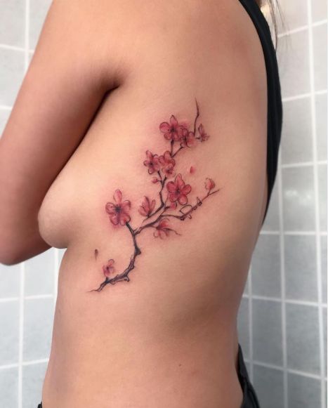 70 Cherry Blossom Tattoo Designs And Ideas To Try In 2023 Cherry Blossom Tattoo Back Shoulder, Cherry Blossom Side Tattoos Women, Back Tattoo Women Spine Cherry Blossoms, Japanese Tattoo Art Cherry Blossom, Cherry Blossom Tattoo Side Ribs, Cherry Blossom Tattoo Rib Cage, Cherry Blossom Tattoo Aesthetic, Tattoo Along Spine, Cherry Blossom Shoulder Tattoo For Women