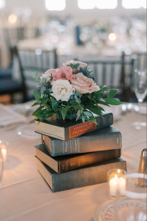 Book Table Decor Wedding, Bookish Wedding Table Decor, Library Themed Centerpieces, Book Table Number, Wedding Centerpiece Books, Wedding Centerpieces Books And Flowers, Notebook Themed Wedding, Hanging Book Page Decorations, Book Themed Table Numbers