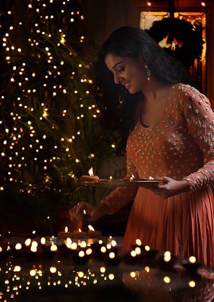 Young woman arranging oil lamps at a diwali festival Natal, Diwali Photography Poses For Women At Home, Diwali Pictures Poses For Women, Karthikai Deepam Images, Diwali Poses With Diya, Diwali Poses For Women At Home, Diwali Images Festivals, Diwali Photoshoot Ideas For Women, Diwali Photography Poses For Women