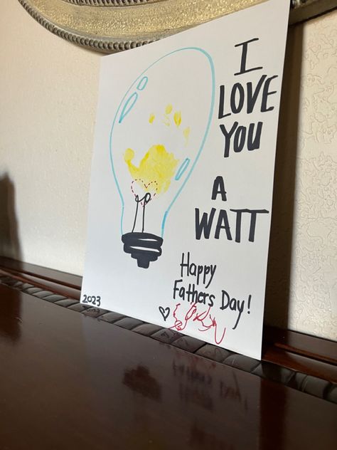 This is a photo of a lightbulb drawn on grey craft paper. There is a light blue bulb surrounding a yellow toddler handprint and a dotted heart indicating the power of love lighting up the bulb. The text reads. I LOVE YOU A WATT Happy Father’s Day!  Signed scribble by toddler. Dated 2023. Baby Art Crafts, Fathers Day Art, Father's Day Activities, Baby Art Projects, Footprint Crafts, Give A Gift, Toddler Arts And Crafts, Kids Daycare, Diy Baby Gifts