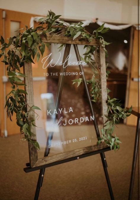 Make a statement by greeting your guests warmly with this stylish acrylic wedding welcome sign. This custom designed framed in a dark wood finish makes for a nice addition to a rustic Boho decor. The sign is available in an array of sizes and frame options. Photo Frame Wedding Sign, Wedding Welcome Sign Picture Frame, Picture Frame Welcome Sign Wedding, Welcome Signs For Wedding Entrance, Wedding Frames Design, Wooden Welcome Signs Wedding, Clear Wedding Welcome Sign, Clear Acrylic Welcome Sign Wedding, A Frame Wedding Sign