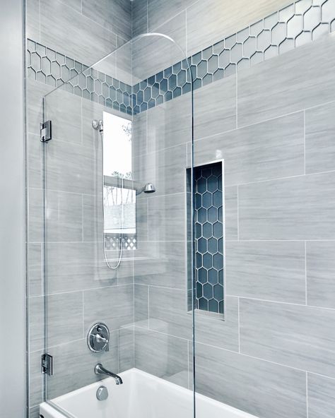 A gorgeous pop of blue really shines in this beautiful, spa-like shower. #showerdesign #showers #showertile #bathrooms #bathdesign #interiordesign #bathrooms #shower #interiors Shower Remodel Blue Tile, Pebble Tile Shower Floor Master Bath, White Gray And Blue Bathroom, Bathroom Shower Tiles Gray, Walk In Shower With Blue Accent Tile, Blue Glass Tile Bathroom Showers, Blue Inspired Bathroom, Small Bathroom With Walk In Shower Ideas Blue, Blue Tile Shower Ideas With Tub