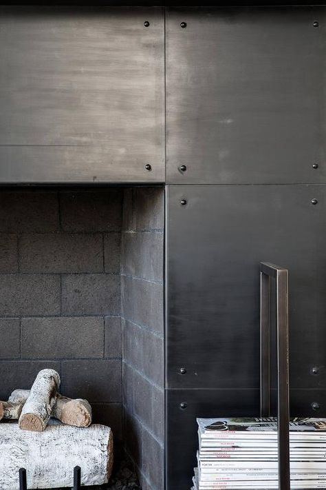 A black metal fireplace is accented with a black brick firebox. Stone Fireplace Makeover Modern, Black Metal Fireplace, Industrial Fireplaces, Subway Tile Fireplace, Industrial Fireplace, Herringbone Fireplace, Grey Stone Fireplace, Fireplace Feature Wall, Slate Fireplace