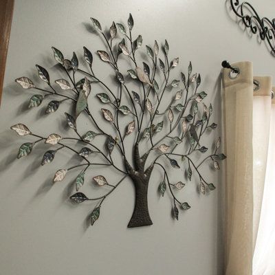 Taking inspiration from nature, this wall hanging puts an artistic twist on the tree with its willowy branches and large leaves. Made from metal, it is a creative design that is easy to install on just about any wall with built-in hangers, and the tri-tone finish in shades of green, off-white, and brown add a subtle touch of color. Display it on a focal wall anywhere indoors or let it greet your guests outside near the front entry. Hang it by the pool, on the patio, or on a fence to bring a touc Nature, Crafty Christmas Gifts, Tree Branch Wall Decor, Tree Indoor, Compass Wall Decor, Tree Branch Wall, Focal Wall, Coastal Wall Decor, Nature Wall Decor