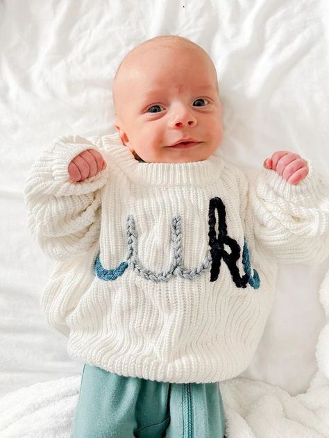 "Production time is approximately 1-2 week. Personalized Hand Embroidered Baby And Toddler Sweater Our adorable hand embroidered \"Name\" sweater is perfect for birth announcements, newborn/family photos, baby shower gifts, birthday gifts, or any occasion! Embroidery is done by hand and may vary. Each sweater is unique as they are custom made with name, sweater color and embroidery color! All custom information for your order will be entered into the personalization box at checkout. **See photos in listing for all sweater and yarn colors. If you would like to add flowers, hearts, or a different color for each letter, or any other design elements, there is an additional fee. Be sure to add this item to your cart during checkout - https://largsflower.etsy.com/listing/1646270068 Product detai Embroidered Name Sweater, Newborn Sweater, Hand Embroidered Name, Name Sweater, January Baby, Newborn Family Photos, Custom Sweaters, Kids Jumpers, Toddler Sweater