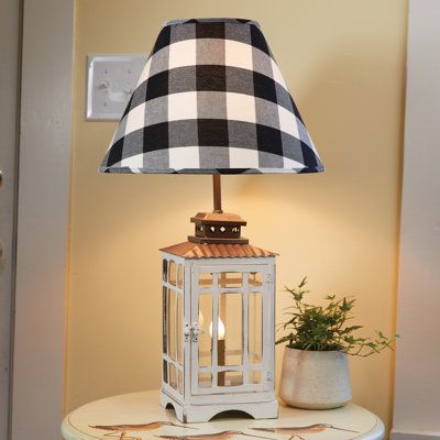 Amplify a country farmhouse interior, beach house, or shabby elegance home with a versatile lighting accent that won't go out of style. Inspired by a lantern, this table lamp has a copper top and metal frame construction in a rustic white finish. The base features glass panels and a functioning door that allows for easy access to change the lower bulb. Pair this table lighting accent with a lovely lampshade, not included, along with a 60 Watt and 7 Watt bulb, both not included. | August Grove® A Country Farmhouse Interior, Interior Beach House, Lantern Table Lamp, White Lantern, Copper Top, Wrought Iron Chandeliers, White Lanterns, Table Lighting, Metal Table Lamp