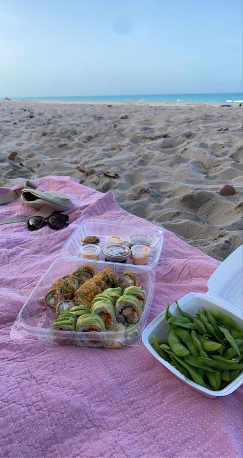 Takeout sushi rolls and edamame on a blanket at the beach during sunset Sushi Beach Picnic, Sushi At The Beach, Snacks On The Beach, Sushi On The Beach, Sushi Edamame, Food Aesthetically, Beach Date Aesthetic, Beach Lunch Ideas, Beach Food Ideas