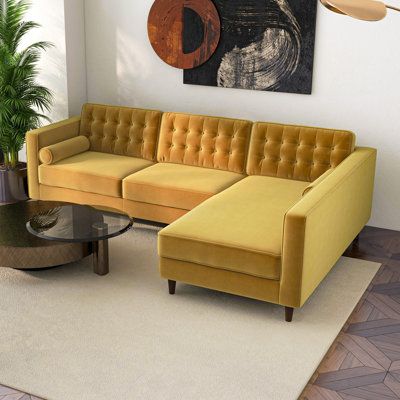 This L-shaped mid-century modern sofa and chaise offers ample space to spread out or sit up as you enjoy a good book solo or cocktails with friends. The frame is made from solid wood and sits on tapered brown-finished feet. Square arms add a clean-lined touch, while the tufted back and matching bolster pillows complete the elegant, elevated look we love. Foam fill throughout adds cozy comfort, and the velvet upholstery offers a luxurious look and feel. Plus, for easy cleaning and to encourage ev Velvet Sectional Living Room, Yellow Sectional, Sectional Living Room, Loft Condo, Couch With Ottoman, Upholstered Couch, Velvet Sectional, Mid Century Modern Sofa, Urban Loft